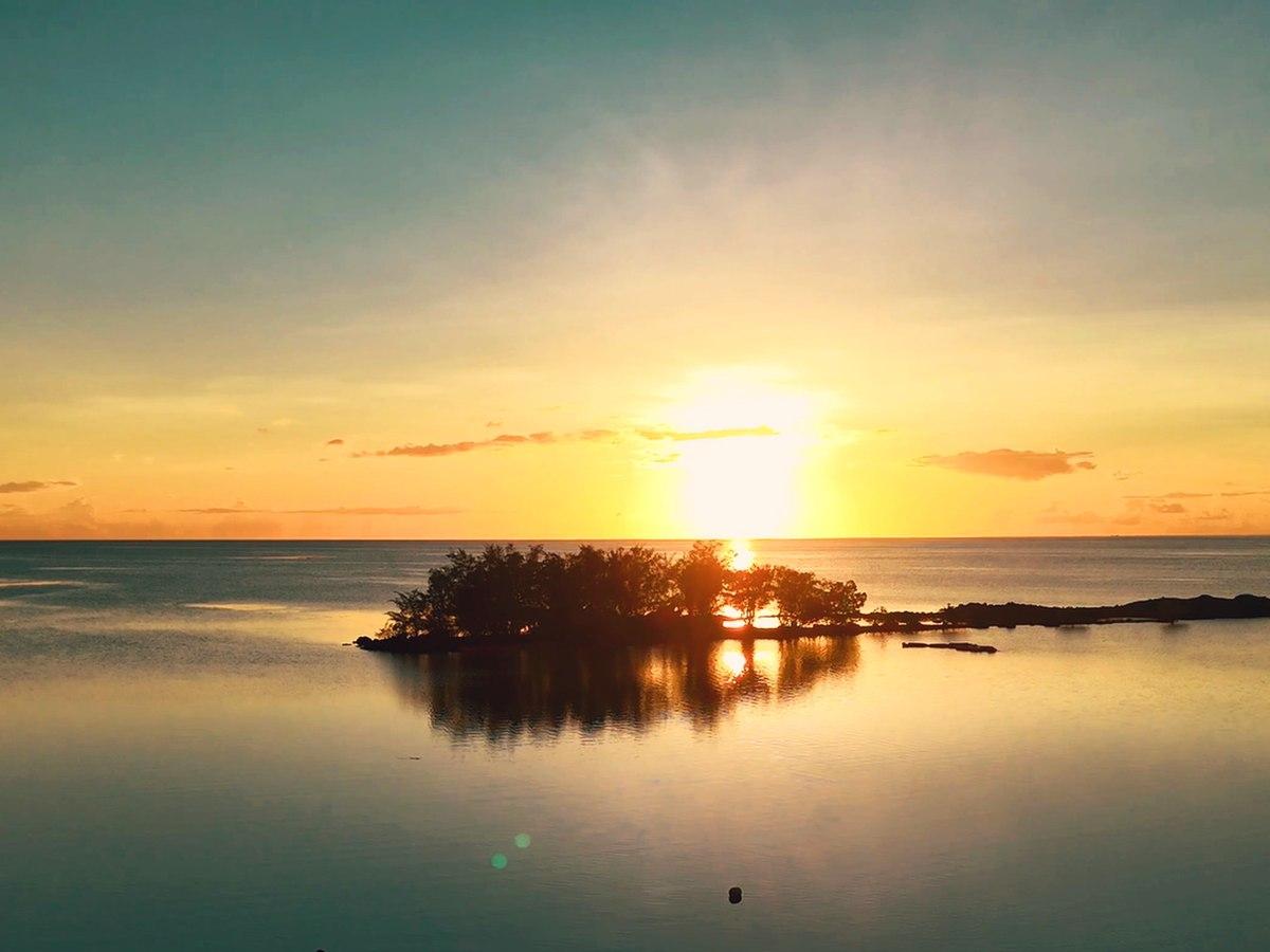 ラグーンに浮かぶ小島と、水面に映る夕陽